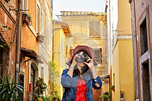 Tourist woman standing and focusing with camera