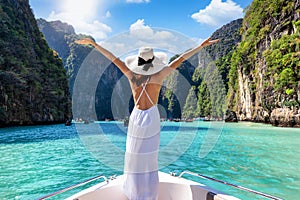 A tourist woman stands on a yacht at the beautiful Phi Phi islands