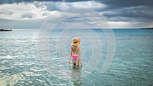 Tourist woman in straw hats for summer in a rose swimsuit Hawaii, Phuket, Maui. Space for text