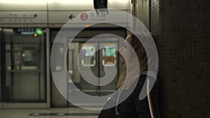 Tourist woman on subway station waiting train on platform. Traveler young woman in underground. City transport. Travel