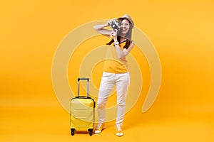 Tourist woman in summer casual clothes, hat with suitcase, retro vintage photo camera isolated on yellow orange