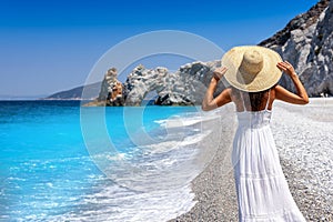 A tourist woman with sunhat enjoys the beautiful beach of Lalaria