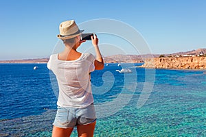 Tourist woman on sunny resort beach at the coast of Red Sea in Sharm el Sheikh, Sinai, Egypt, Asia in summer hot. Ð¡oral reef and