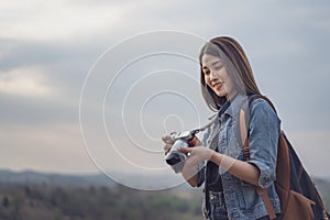 Tourist woman taking photo with her camera in nature