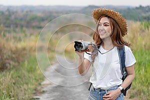 Tourist woman taking photo with her camera in nature