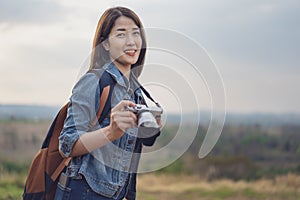 Tourist woman taking photo with her camera in nature