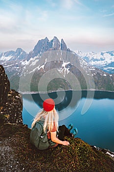 Tourist woman traveling in Norway alone enjoying fjord view hiking in mountains outdoor with backpack healthy lifestyle