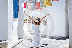 A tourist woman walks through the whitewashed streets of Naxos island