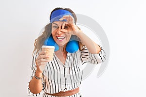 Tourist woman wearing neckpillow sleep mask drinking coffee over isolated white background with happy face smiling doing ok sign