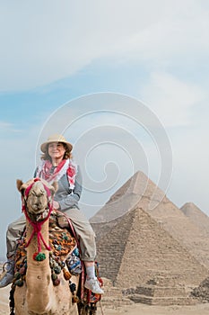 tourist woman riding a dromedary in front of pyramids. Egypt, Cairo - Giza photo