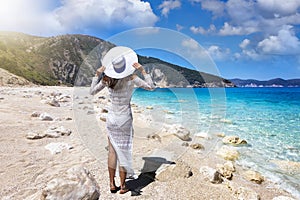 A tourist woman with white hat enjoys the scenery of Myrtos beach, Kefalonia, Greece