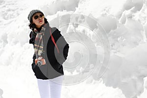 Tourist woman in the white snow wall background. Winter season concept