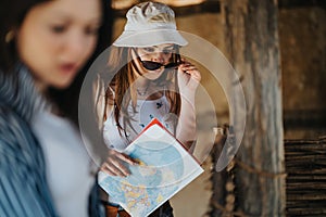 Tourist women exploring ancient ruins with a map in a rustic setting