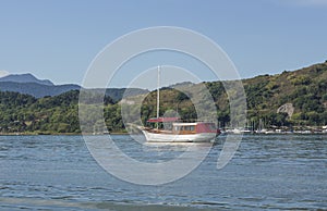 A touristic boat anchored close to the marina of Paraty, a village surrounded by the Atlantic Forest, Brazil.