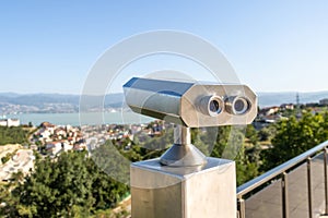 Touristic coin operated telescope binoculars look at the city landscape view