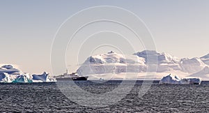 Touristic cruise liner among blue icebergs close to Cuverville Island