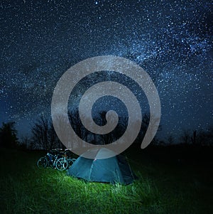 Touristic cycling camp at the night under a starry sky