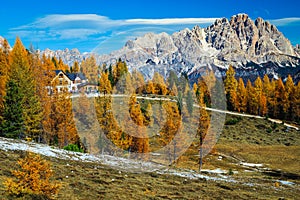 Touristic mountain shelter in the colorful autumn forest, Dolomites, Italy