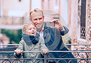 Touristic selfie - father and son take a picture with a smartphone