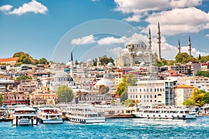 Touristic sightseeing ships in Golden Horn bay of Istanbul and view on Suleymaniye mosque with Sultanahmet district against blue