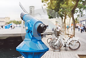 Touristic telescope look at the city with view of Barcelona Spain, close up old blue binoculars on background viewpoint the port