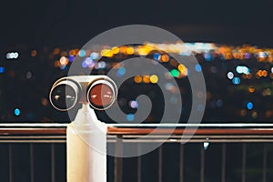 Touristic telescope look at city with view of Barcelona Spain, close up old metal binoculars on background viewpoint, hipster coin