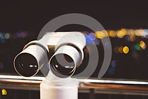 Touristic telescope look at city with view of Barcelona Spain, close up old metal binoculars on background viewpoint, hipster coin