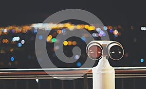 Touristic telescope look at city with view of Barcelona Spain, close up old metal binoculars on background viewpoint, hipster coin