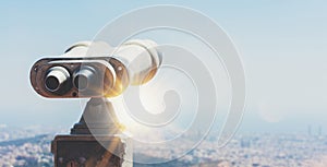 Touristic telescope look at the city with view of Barcelona Spain, close up old metal binoculars on background viewpoint overlook