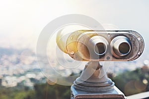 Touristic telescope look at the city with view of Barcelona Spain, close up old metal binoculars on background viewpoint overlook