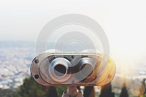 Touristic telescope look at the city with view of Barcelona Spain, close up old metal binoculars on background viewpoint overlook