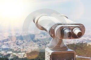 Touristic telescope look at the city with view of Barcelona Spain, close up old metal binoculars on background viewpoint overlook