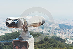 Touristic telescope look at the city with view of Barcelona Spain, close up old metal binoculars on background viewpoint overlook