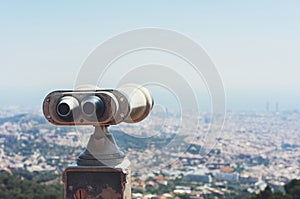 Touristic telescope look at the city with view of Barcelona Spain, close up old metal binoculars on background viewpoint overlook