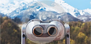 Touristic telescope look at the city with view snow mountains, closeup binocular on background viewpoint observe vision, metal