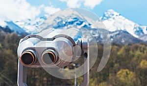 Touristic telescope look at the city with view snow mountains, closeup binocular on background viewpoint observe vision, metal