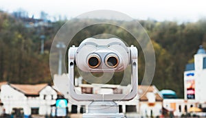 Touristic telescope look at the city with view snow mountains, closeup metal binocular on background viewpoint observe vision