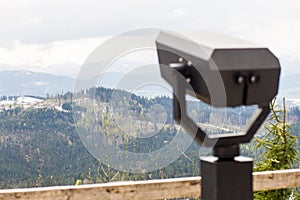 Touristic telescope look on top of mountains, close up metal binoculars on background viewpoint overlooking mountain