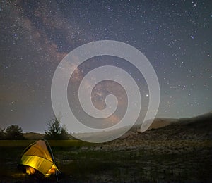 Touristic tent under a starry sky with milky way