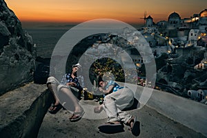 Tourists with backpacks sleeping at the Oia village