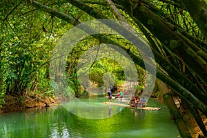 Turistas sobre el bambú balsa conduciendo sobre el un rio 
