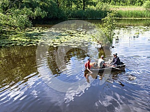 Tourists in a boat. Tourists crossing to the other shore. A boat with three people is going down the river