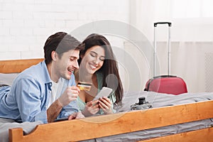 Tourists booking tickets, using phone and credit card
