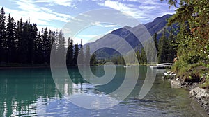 Tourists canoeing on Bow River in summer time. Banff Canoe Docks, leisure water activities in Banff National Park