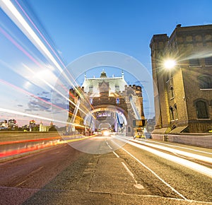 Tourists and car light trails at night along Tower Bridge, London in summer