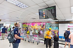 Tourists check air flight form display at Phuket international airport