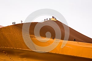 Tourists climbing sand dune Sossusvlei namibia