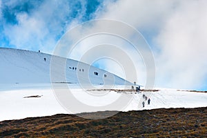 Tourists climbs for camping to the snow-capped mountain top. Con