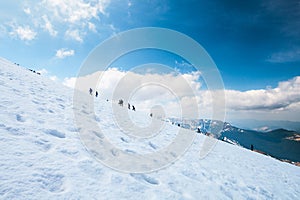 Tourists climbs for camping to the snow-capped mountain top. Con