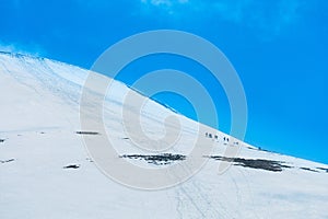 Tourists climbs for camping to the snow-capped mountain top. Con